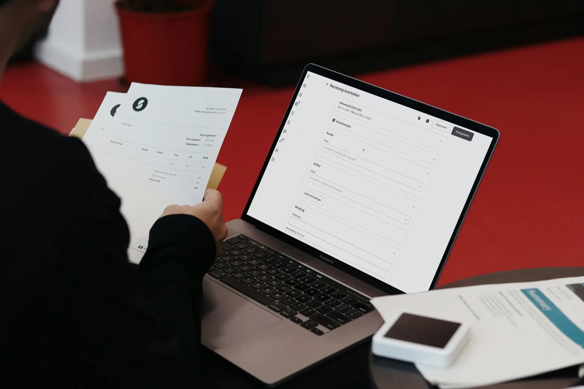 A person balancing traditional documents with an online invoice system. SumUp combines convenience and efficiency for businesses. - Sumup, Unsplash