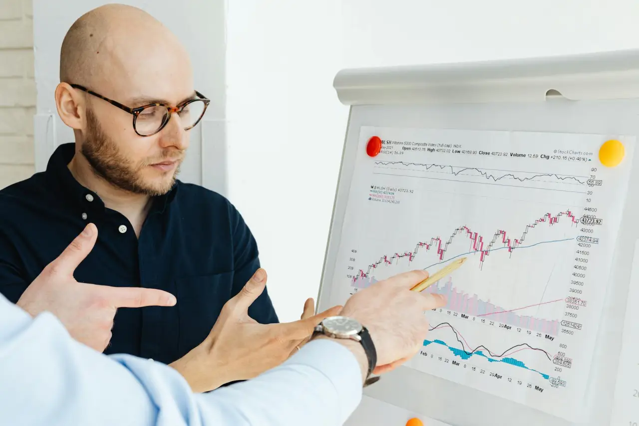 Man in eyeglasses studying financial graphs