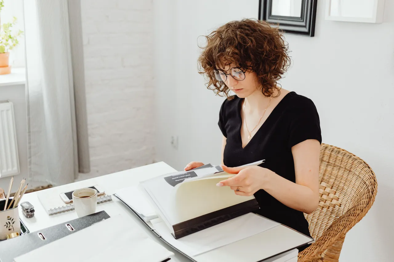 A woman in a black shirt reading documents