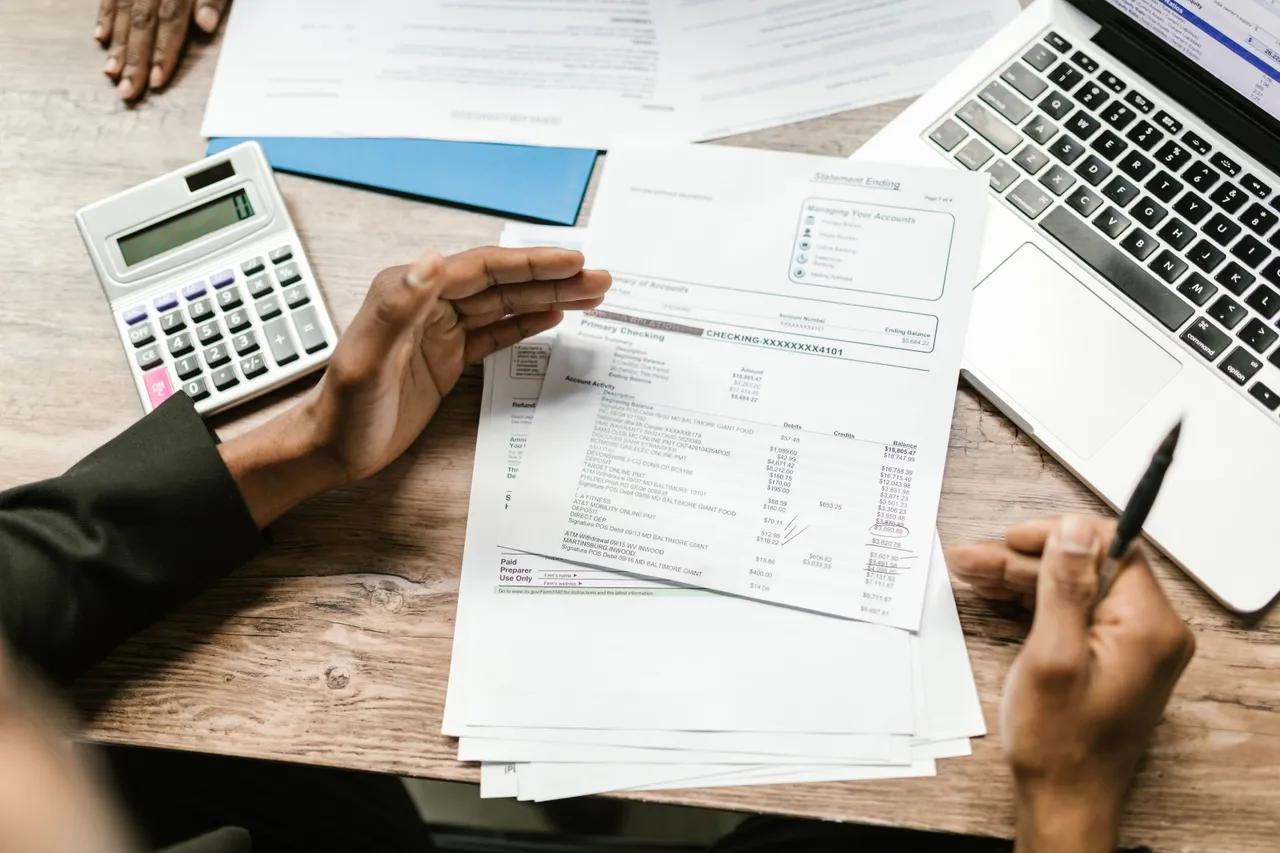 White papers with financial statements on a wooden table