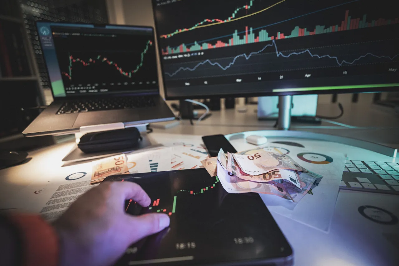 Hand on tablet displaying stock quotes with euro cash currency