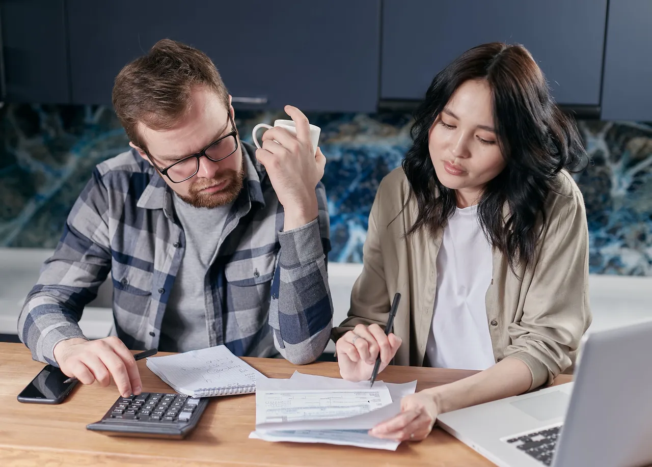 A couple reviewing their bills at a kitchen table
