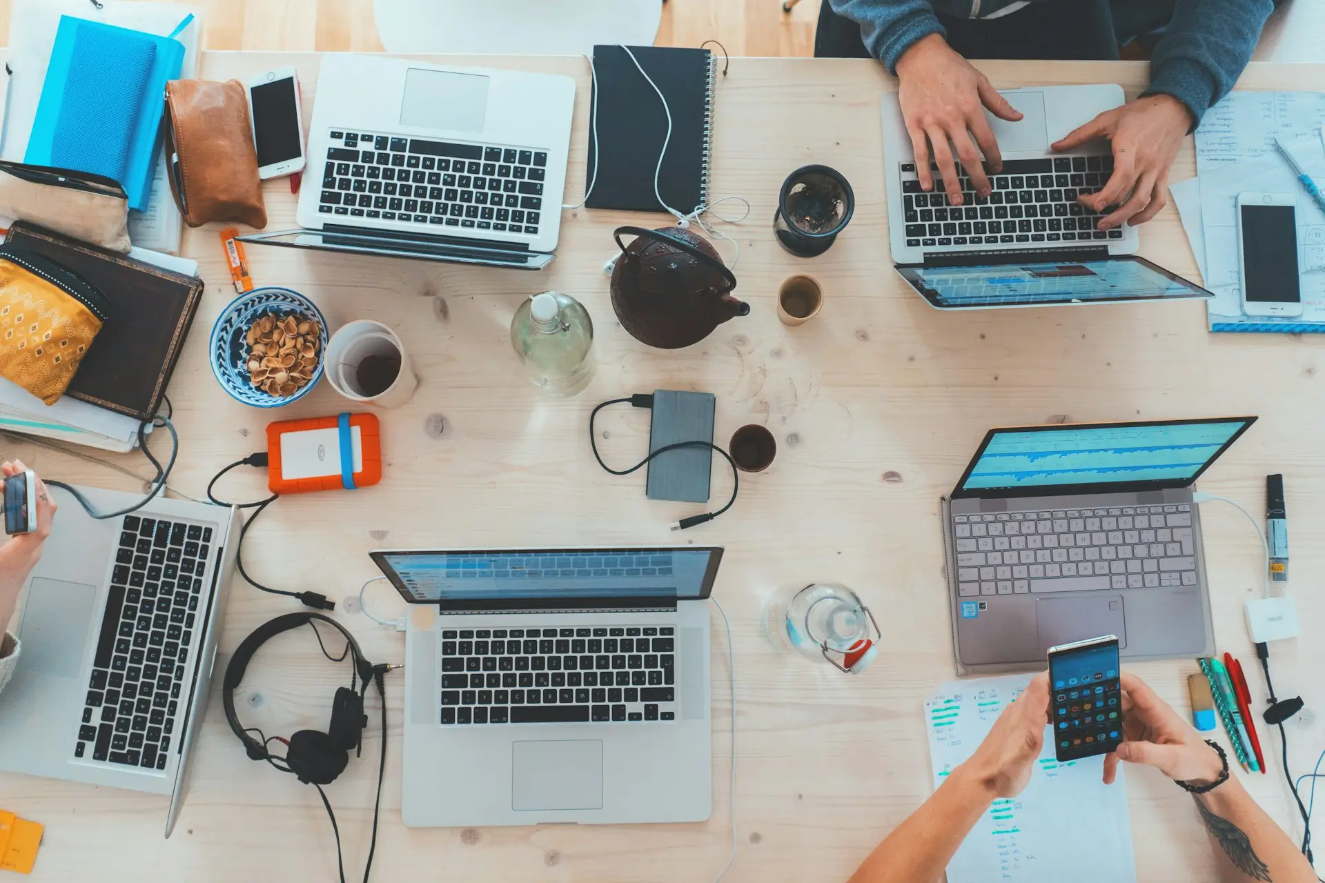 Illustration of a group of people working on various tasks with their laptops on a desk