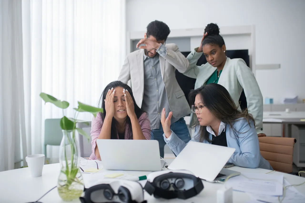 Employees brainstorming while looking at the screen of a laptop