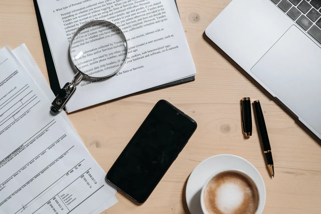 Documents beside a laptop