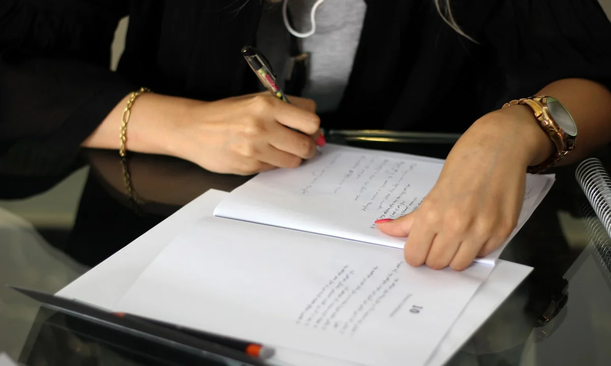 A person writing on a piece of paper (Mana A., Unsplash)